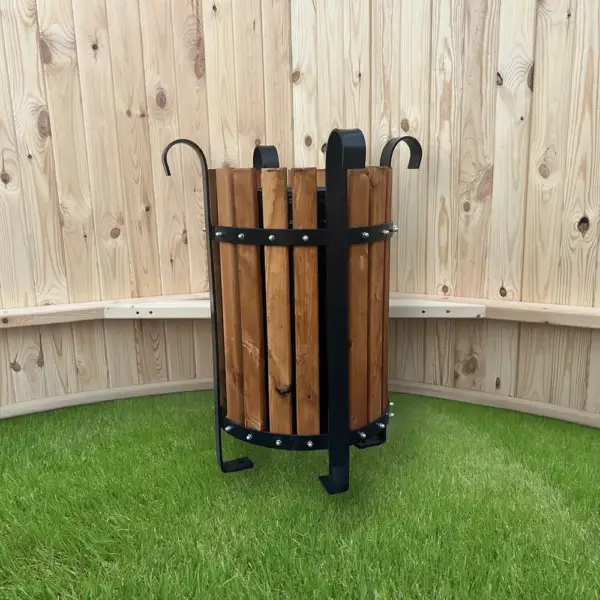 Çimen ve ahşap önünde bulunan park çöp kovası